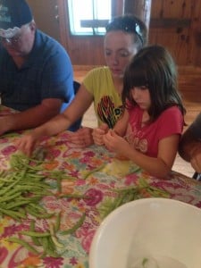Madison and her Mom stringing beans and her Grandpa, slicing them.