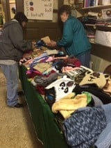 Pauline helping a custormer with hats, gloves and scarves