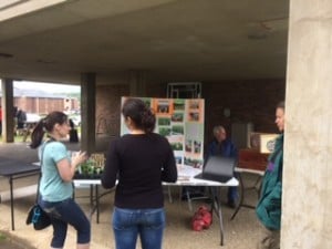 Earth Day at LMU.  Junior Snelson is in the background with his bee exhibit. Marisol is telling a student about the organic  garden.