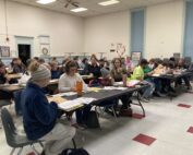 An image of workshop participants sitting around tables.