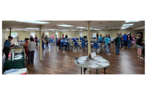 The photo shows a large group of people attending the Grow Appalachia meeting. 
