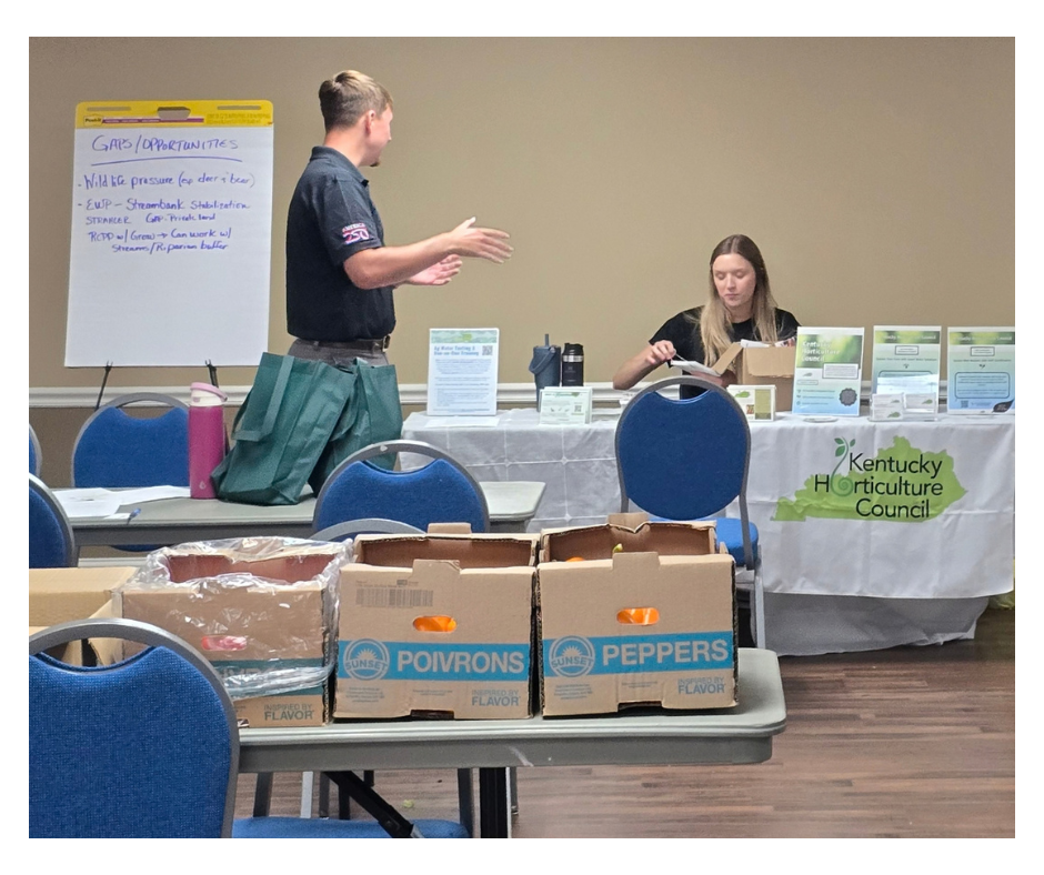 A younf man from KOAP discusses resources with the rep from the Kentucky Horticulture Council.
